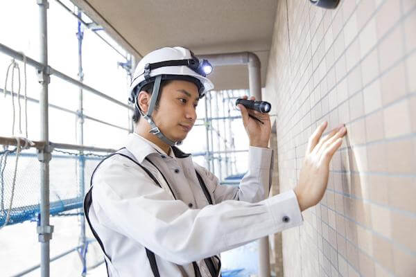 家の壁を調べる業者
