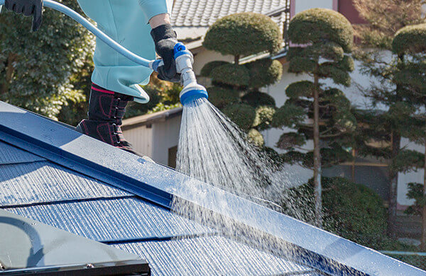 屋根の上での散水作業