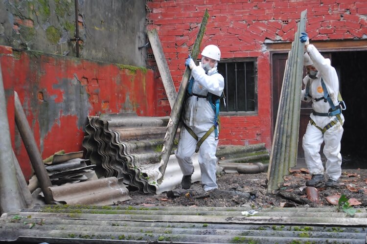アスベストの入った屋根材を撤去する作業員